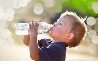Kleiner junge mit einer Wasserflasche