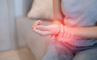 Frau hält schmerzendes Handgelenk