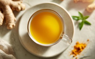 Tasse mit Kurkumatee auf hellem Untergrund