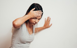Frau mit Schwindel stützt sich ab