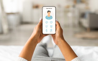 Eine Person hält ein Smartphone in den Händen, auf dessen Bildschirm eine medizinische Service-App mit einem Arzt-Symbol zu sehen ist.